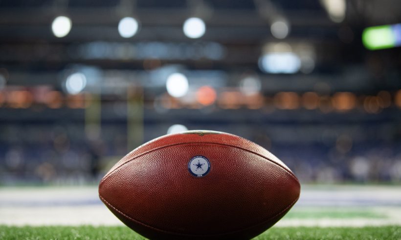 A NFL football with the Dallas Cowboys logo on the field before the NFL game between the Indianapolis Colts and Dallas Cowboys on December 16, 2018, at Lucas Oil Stadium in Indianapolis, IN.