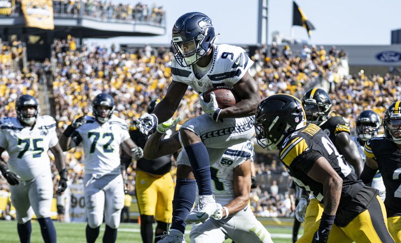 Seattle Seahawks running back Kenneth Walker III (9) jumps in to the end zone after carrying the ball 19 yards for a touchdown while Seattle Seahawks wide receiver Jaxon Smith-Njigba (11) helps block Pittsburgh Steelers defenders in the fourth quarter during the game between the Pittsburgh Steelers and Seattle Seahawks at Acrisure Stadium on September 14, 2025 in Pittsburgh, PA.